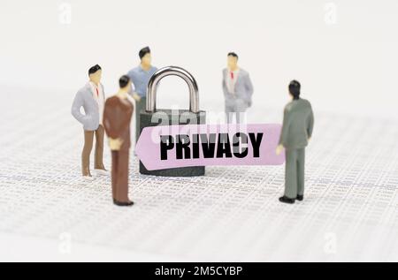 The concept of security in business. There are figures of people on business reports, a padlock with a sticker on which it is written - Privacy Stock Photo