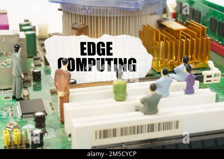 Technology and computer concept. On the motherboard there are figures of people and torn paper with the inscription - Edge Computing Stock Photo