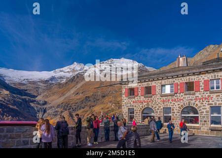 ALP GRUEM, SWITZERLAND - OCTOBER 28,2022: People at the Bernina Express station of Rhaetian railway on a autumn day at Alp Gruem Stock Photo