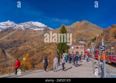 ALP GRUEM, SWITZERLAND - OCTOBER 28,2022: People at the Bernina Express station of Rhaetian railway on a autumn day at Alp Gruem Stock Photo