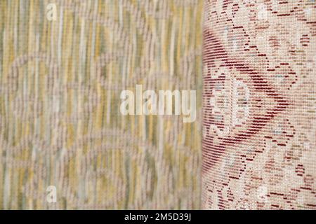 Front and back side of pastel multi-colored rug with pattern, which is canvas with base and vertical cotton rows of beige color. Close up of textile material carpet texture. Concept of textures. Stock Photo