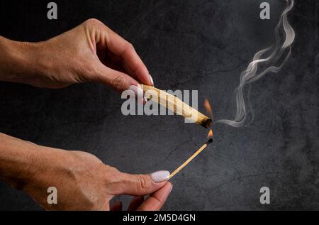 palo santo burning in front of dark background Stock Photo