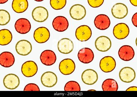Pattern made of backlit citrus fruits slices on white background Stock Photo