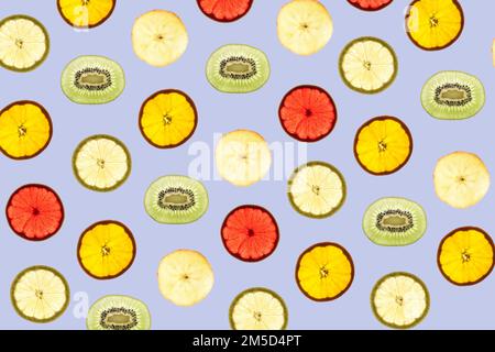 Pattern made of backlit different fruits slices on blue background Stock Photo