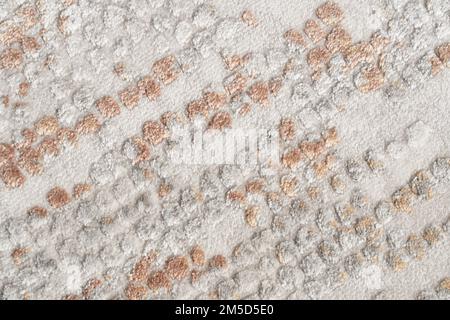 Fragment of decorative velours, spotty carpet fabric pattern, background photo texture. Close up of patchy beige and grey relief, short pile carpet ornament. Backgrounds and textures concept. Stock Photo