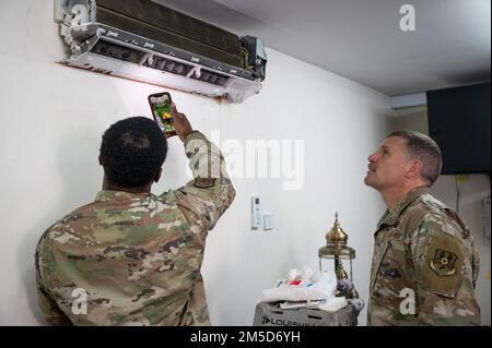 U.S. Air Force Airman 1st Class Jaydon Smith, 380th Expeditionary Civil Engineer Squadron HVAC apprentice, shows Brig. Gen. Andrew Clark, 380th Air Expeditionary Wing commander, the dirt build-up on the blower wheel of an AC unit at Al Dhafra Air Base, United Arab Emirates, March 3, 2022. Clark is working with Airmen around ADAB as part of a “Leadership on Location” program to emphasize the contributions made to the Air Force mission in every squadron. Stock Photo