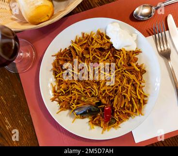 Traditional Valencian fideua de mariscos with sauce alioli Stock Photo