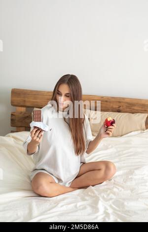 Cute pregnant woman choosing what to eat Stock Photo