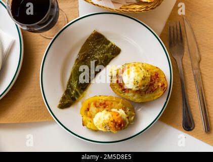 Twice baked potatoes stuffed with meat, jam, cheese and egg Stock Photo