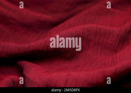 Red fabric background. Red cloth waves background texture. Red fabric cloth textile material. Stock Photo