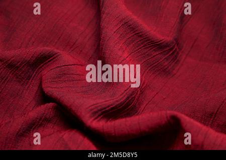 Red fabric background. Red cloth waves background texture. Red fabric cloth textile material. Stock Photo