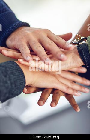 United in the name of business. Closeup shot of a diverse team of colleagues joining their hands together in unity. Stock Photo