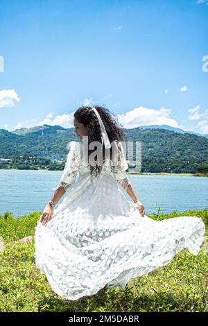 A back view of Sri Lankan woman posing in white dress in the open air Stock Photo