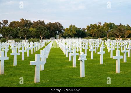 Grave markers of the deceased U.S. service members from the African campaign are revealed by the sunset at the North African American Cemetery in Tunis, Tunisia on March 3, 2022.    The 173rd Airborne Brigade is the U.S. Army's Contingency Response Force in Europe, providing rapidly deployable forces to the United States European, African, and Central Command areas of responsibility. Forward deployed across Italy and Germany, the brigade routinely trains alongside NATO allies and partners to build partnerships and strengthen the alliance. Stock Photo