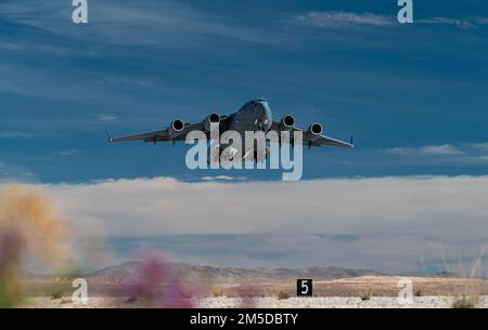 A C-17 Globemaster III assigned to the 60th Air Mobility Wing, Travis Air Force Base, Calif., takes off from Nellis Air Force Base, Nevada, March 3, 2022. The aircraft can perform tactical airlift and airdrop missions and can transport litters and ambulatory patients during aeromedical evacuations. Stock Photo