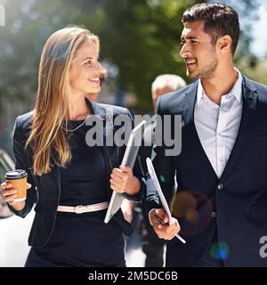 As productive out of office as they are in it. corporate colleagues having a discussion while walking down the street. Stock Photo