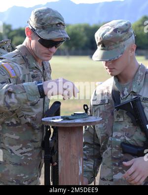 U.S. Army Reserve Soldier Staff Sgt. Jeremy Dornbusch, an infantryman assigned to the 100th Battalion, 442nd Infantry, helps Hawaii Army National Guard (HIARNG) Soldier, Sgt. Trevor J. Castro, a helicopter repairer with 1-183 Aviation Regiment, 103rd Troop Command, with compass during a pace count exercise in preparation for the land navigation event of the HIARNG Best Warrior Competition (BWC), Waimanalo, Hawaii, March 4, 2022. The annual Best Warrior Competition (BWC) is where Soldiers and Non-Commissioned Officers (NCOs) compete in events to test their physical and mental endurance as a Sol Stock Photo