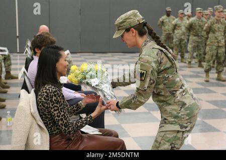 Mrs. Alexis Siriani, spouse of Lt. Col. Michael Siriani, the 228th Transportation Battalion’s incoming Commander, is presented with a bouquet of closed yellow roses during a change of command ceremony at Fort Indiantown Gap, Annville, Pa. March 5, 2022. Stock Photo