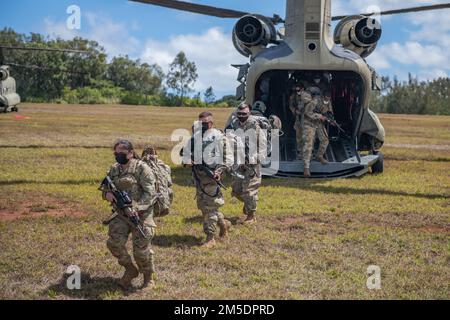 Hawaii Army National Guard and U.S. Army Reserve Best Warrior competitors load onto a CH-47 Chinook helicopter during the Hawaii Best Warrior Competition at Schofield Barracks, Hawaii, March 5, 2022. Competitors and staff were flown to an unknown training area to conduct a foot march as part of the competition. Stock Photo