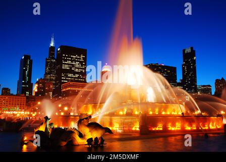 The water of the Buckingham Fountain shoots into the sky from Grant Park complimenting the city lights of Chicago Stock Photo
