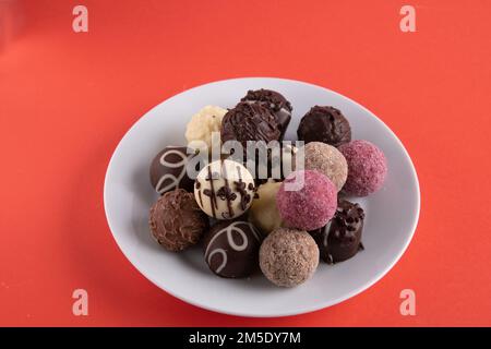 photo round sweets on a white plate on a red background Stock Photo