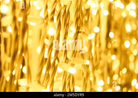 Garland with warm yellow light close-up in defocus. Festive bright background Stock Photo