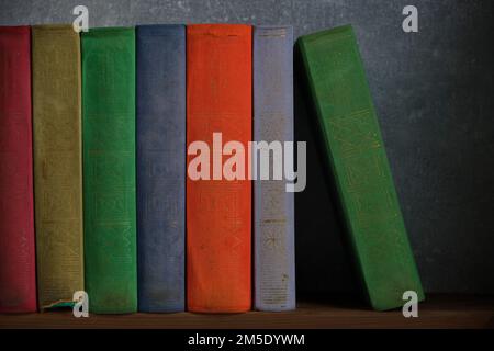 Home library of old battered retro books with colored spines Stock Photo