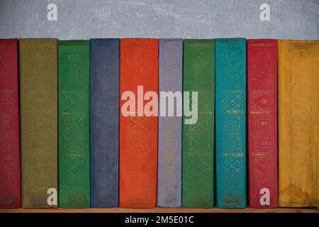 Home library of old battered retro books with colored spines Stock Photo