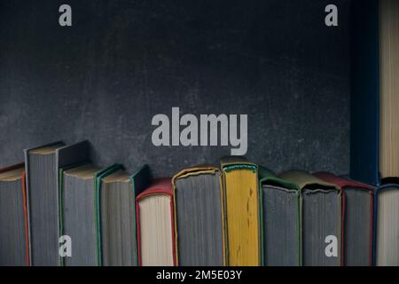 Home library of old battered retro books with colored spines Stock Photo