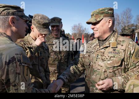 U.S. Army Gen. Mark A. Milley (right), Chairman of the Joint Chiefs of Staff, prepares to hand a coin to Command Sgt. Maj. Robert N. Christensen, command sergeant major of 1-3rd Attack Battalion, 12th Combat Aviation Brigade at Camp Adazi, Latvia, on March 5, 2022. Milley, the highest-ranking U.S. military leader, was joined by United States Ambassador to Latvia John Carwile, Latvian Lt. General Leonīds Kalniņš, Chief of Defense, and Gen. Christopher G. Cavoli, Commanding General of U.S. Army Europe and Africa, for the visit to U.S. and Latvian soldiers. Milley said that recent U.S. troop depl Stock Photo