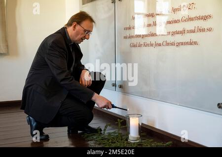 Marktl, Germany. 28th Dec, 2022. Dr. Franz Haringer, Theological Director of the Pope's Birthplace, lights a candle for Pope Benedict XVI in the Birth Room. Credit: Lennart Preiss/dpa/Alamy Live News Stock Photo