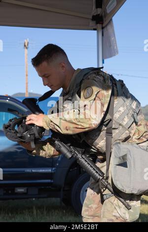 Hawaii Army National Guard (HIARNG) soldier, Sgt. Trevor J. Castro, a helicopter repairer, assigned to 1-183rd Aviation Regiment, 103rd Troop Command, dons his gas mask for the Expert Soldier Badge (ESB) tasks event, Schofield Barracks, Hawaii, March 6, 2022. The ESB tasks was the second to last event for the annual Best Warrior Competition (BWC). Stock Photo