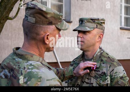 Maj. Gen. Douglas A. Sims II, commanding general of the 1st Infantry Division and Fort Riley, pins the Meritorious Service Medal to Sgt. Maj. Robert S. Wilson, outgoing 1st Infantry Division Forward Sergeant Major, at Poznan, Poland, March 7, 2022. The Meritorious Service Medal is awarded to any member of the armed forces of the United States who distinguish themselves by either outstanding achievement or meritorious service. Stock Photo