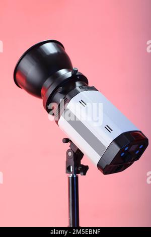 studio flash on a tripod and pink background Stock Photo