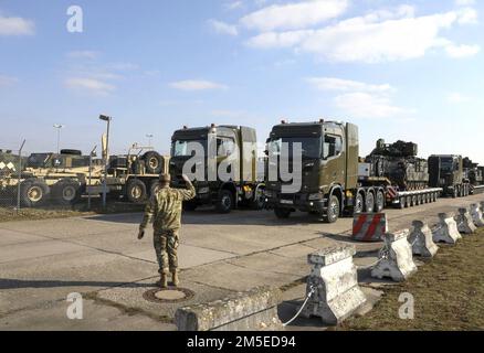 Bundeswehr Heavy Equipment Transport Systems (HETS) carrying American Bradley Fighting Vehicles (BFVs) are given the green light and depart Coleman Barracks, Germany on March 7, 2022. The Bundeswehr work side‐by‐side with American partners to support the Army Prepositioned Stock program, help assure our Allies and deter Russian aggression. Stock Photo