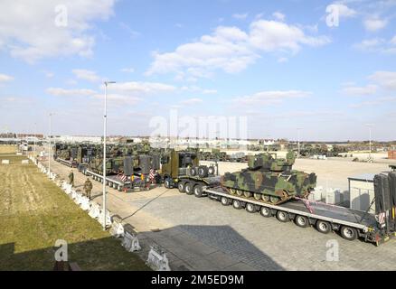 Bundeswehr Heavy Equipment Transport Systems (HETS) carrying American Bradley Fighting Vehicles (BFVs) are staged and inspected for onward movement at Coleman Barracks, Germany on March 7, 2022. The Bundeswehr work side‐by‐side with American partners to support the Army Prepositioned Stock program, help assure our Allies and deter Russian aggression. Stock Photo