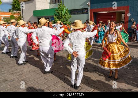 Dancers from Villa de San Juan Cacahuatepec dance the jarabe on the street during Guelaguetza in Oaxaca, Mexico.  The jarabe is a dance about courtshi Stock Photo