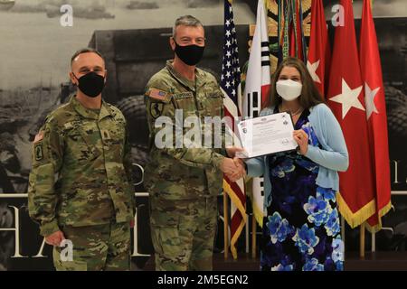 Maj. Gen. David Lesperance, the commanding general of the 2nd Infantry Division/ROK-U.S. Combined Division, and Command Sgt. Maj. Shawn Carns, the senior enlisted advisor of the 2ID, present the 'Heart of the Brigade Award' to Mrs. Tina Dougher. Dougher received the award for her efforts amounting in over 500 hours of volunteer work assisting Soldiers and their families within the 2nd Combat Aviation Brigade. Stock Photo