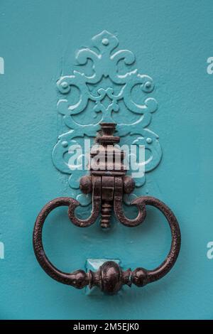 Closeup view of beautiful black vintage brass door knocker isolated on bright blue wooden door, Toulouse, France Stock Photo