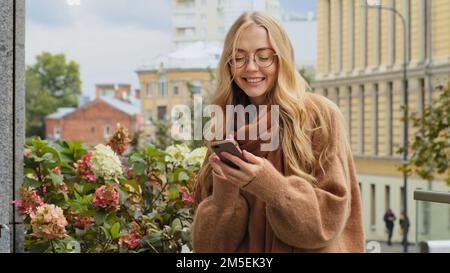 Happy smiling girl Caucasian lady woman female businesswoman with phone smartphone cellphone browsing buying texting searching in Internet service Stock Photo