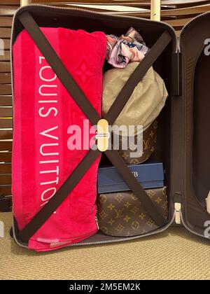 Honolulu, HI - December 26, 2022: Louis Vuitton designer accessory set including towel, cap and suitcase Stock Photo