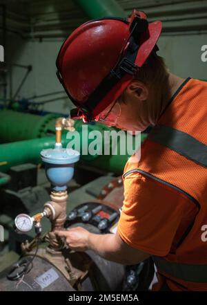 AIEA, Hawaii (March 8, 2022) - Matt Cornman, a Naval Facilities Engineering Systems Command contractor, performs a routine visual inspection on a Red Hill Well water pipe that connects to a Granular Activated Carbon System at the Red Hill Well under an interagency-approved pumping and filtration plan. The U.S. Navy is working closely with the Hawaii Department of Health, U.S. Environmental Protection Agency and the U.S. Army to restore safe drinking water to Joint Base Pearl Harbor-Hickam housing communities through sampling and flushing, and the recovery of the Red Hill Well. For detailed inf Stock Photo