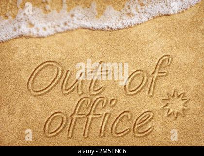 Out of office sign on beach sand Stock Photo