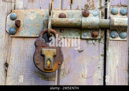 Rusty bolt and padlock in an old wooden door Stock Photo