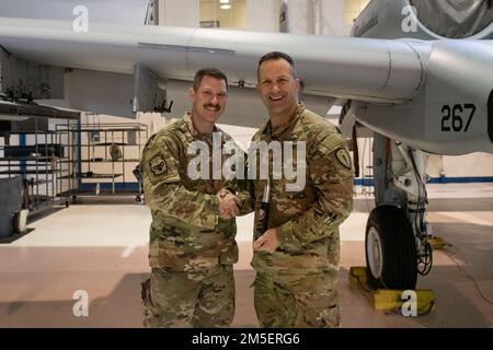 U.S. Army Brig. Gen. Justin L. Mann, Director of the Joint Staff for the Indiana National Guard, receives a spent GAU-8 Avenger 30 mm cannon round from Senior Master Sgt. Arek C. Howe, Sortie Support NCOIC March 9, 2022, at the 122nd Fighter Wing, Fort Wayne, Indiana. The GAU-8 Avenger 30 mm cannon is used in the A-10 Thunderbolt II aircraft assigned to the 122nd Fighter Wing. Stock Photo