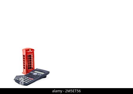 Red phone booth with money box london, penny or piggy bank on coins at white background. Saving money concept idea photo hd. Saving money box or piggy Stock Photo