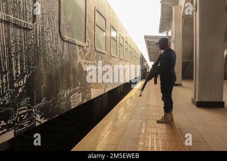 Nigerian security personnel stand guard near a moving trian at Idu Railway station. The train service resumed linking the capital city with a northern city eight months after it was suspended following one of the most high-profile attacks in the country. Gunmen with explosives in March blew up the tracks, assaulted the train travelers between Abuja and Kaduna, and kidnaped some of its passengers and opened fire killing eight people, while some sustained injuries. Nigeria. Stock Photo