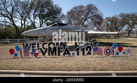 Signs welcoming home Marine Fighter Attack Squadron 112, Marine Aircraft Group 41, Marine Forces Reserve are displayed in front of an F-18 Hornet outside the gate of Naval Air Station Joint Reserve Base Fort Worth, Texas, March 9, 2022. The Marines and Sailors with VMFA-112 completed a six month deployment to the INDOPACOM area of responsibility to promote regional stability and a free and open Indo-Pacific. Stock Photo
