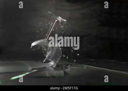Broken wineglass. crushed glass with water drops on black surface Stock Photo
