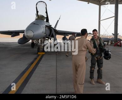 A U.S. Marine Corps F/A-18 Hornet pilot assigned to the Marine Fighter Attack Squadron 115 shakes hands with a Royal Saudi Air Force member at King Faisal Air Base, Saudi Arabia, in support of Operation Agile Spartan II March 9, 2022. OAS II is focused on operational test and evaluation of Agile Combat Employment competencies developed by Ninth Air Force (Air Forces Central) headquarters, individual Air Expeditionary Wings, sister services, and our partner nations through multiple theater-wide events. Stock Photo